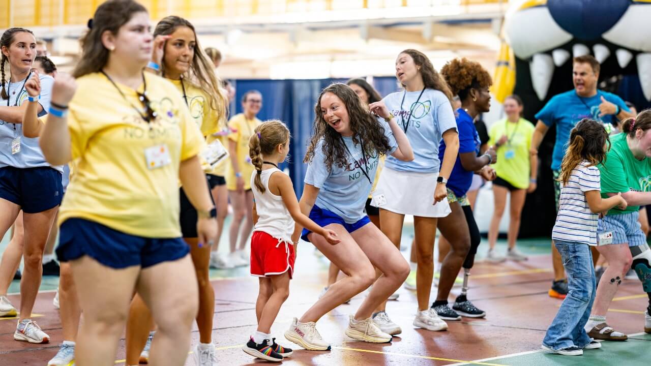 Student volunteer and camper dancing