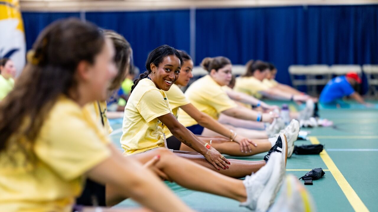 Student volunteers stretching and smiling