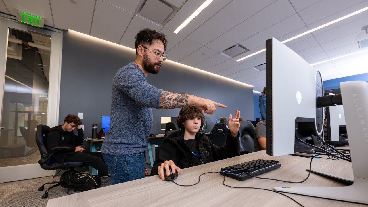 Faculty member and student pointing to computer screen