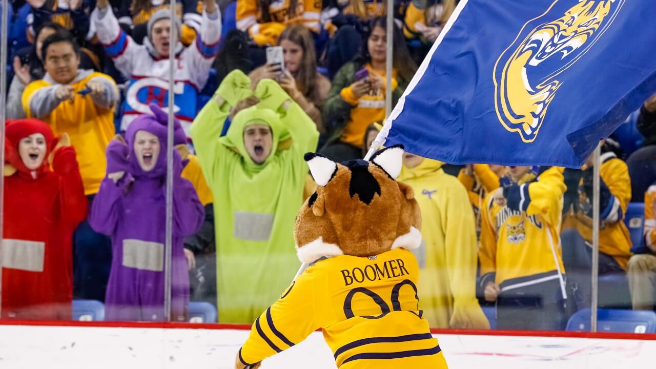Students and Boomer cheer at ice hockey game
