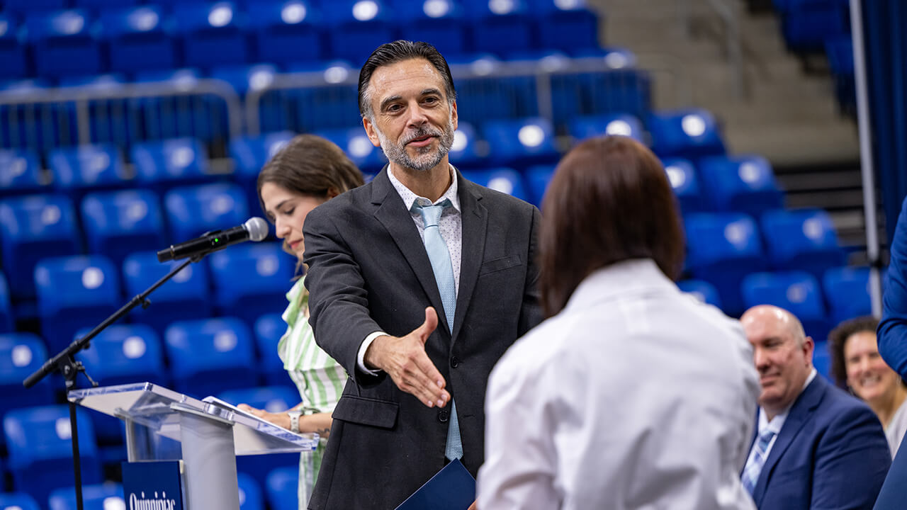 Dean shaking student's hand