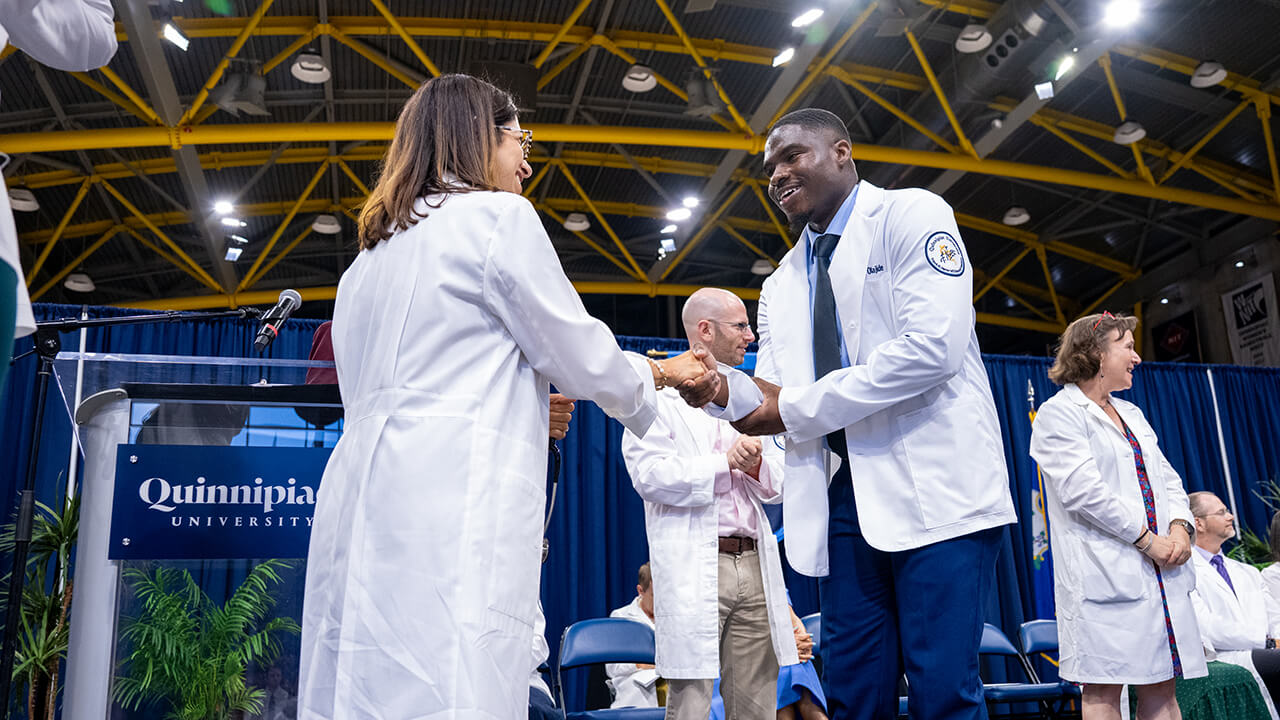 Student and dean shaking hands