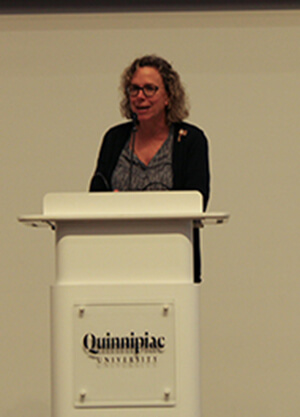 Liz Brown standing at the Quinnipiac podium