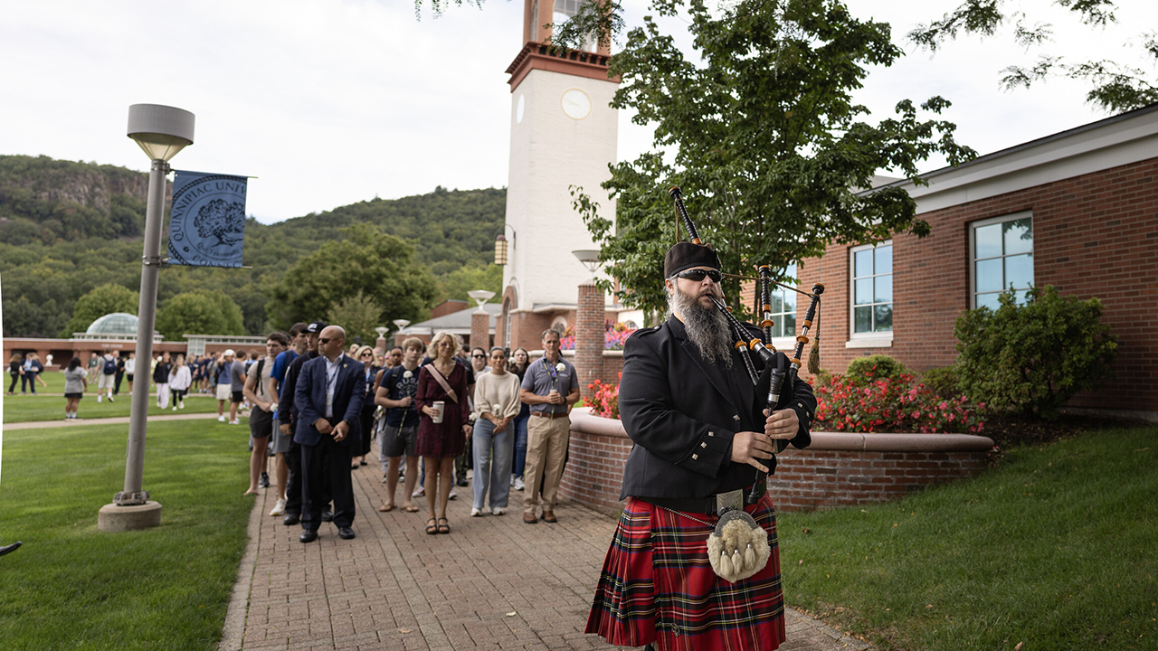 Bagpiper leading procession away from library