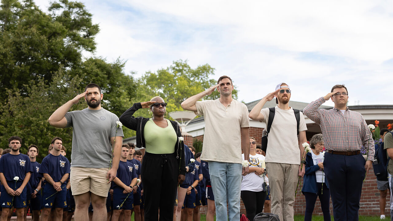 Five people saluting towards the American flag