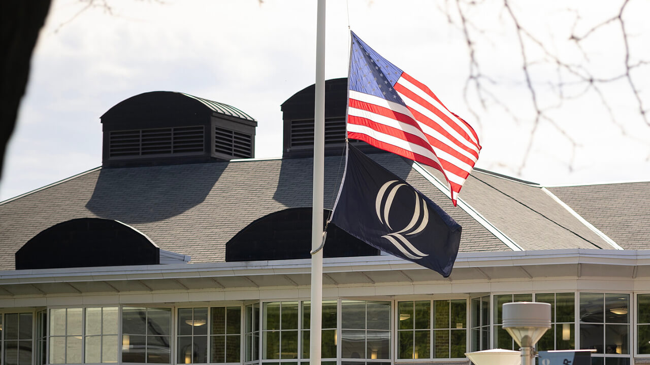 The American and Quinnipiac flag at half mast